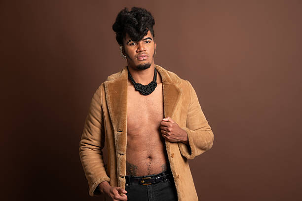 istock Stylish man opening fur coat and showing abs on brown background 2210269537