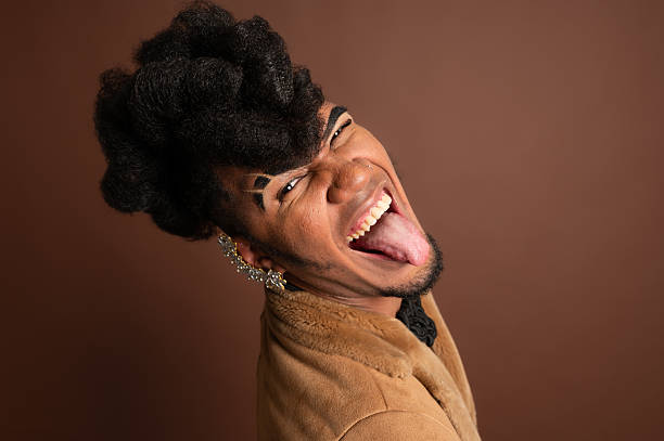 waist up shot of a nerd looking black man with big afro hair and big glasses in colourful sweater, looking away
