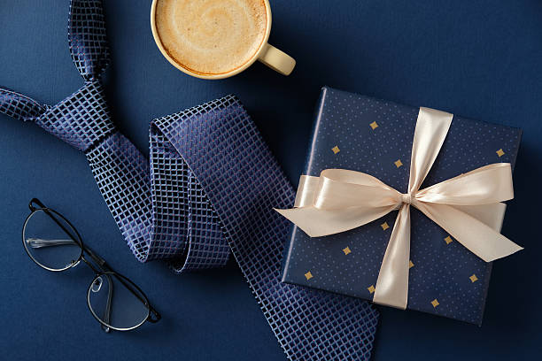 istock Father's Day flat lay with gift, tie, coffee and glasses on a dark blue background. Perfect for celebrations, gifts and special occasions. 2210270713