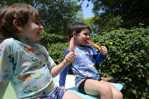 istock brothers eating an icecream in a pool 2210274589