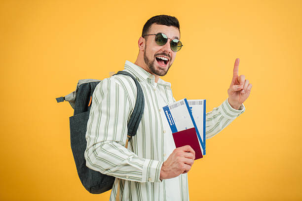 istock Excited traveler holding travel documents and gesturing while preparing for an upcoming trip to an exciting destination with enthusiasm and joy radiating from his expression and posture 2210276304