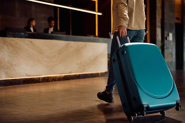 istock Close up of man with suitcase walking into a hotel. 2210276485