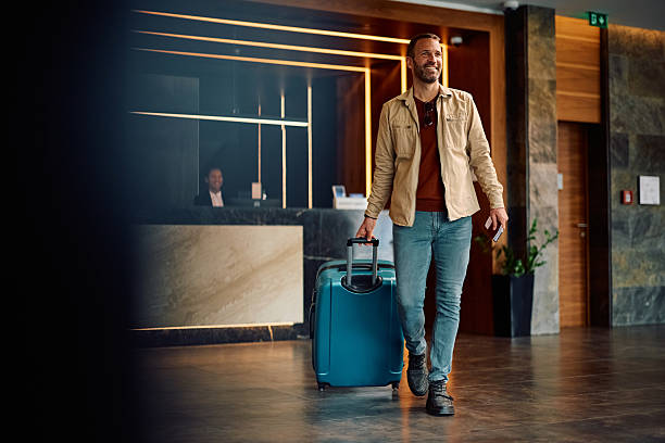 istock Happy traveler with suitcase leaving the hotel. 2210276514