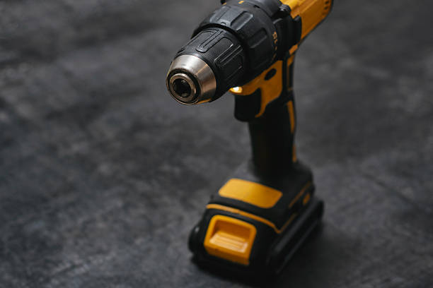 istock Yellow cordless drill rests on a dark textured surface. Powerful tool for construction and DIY projects. 2210276602