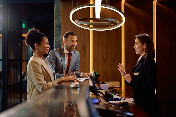 istock Business colleagues talking to a receptionist while checking in at the hotel. 2210276673