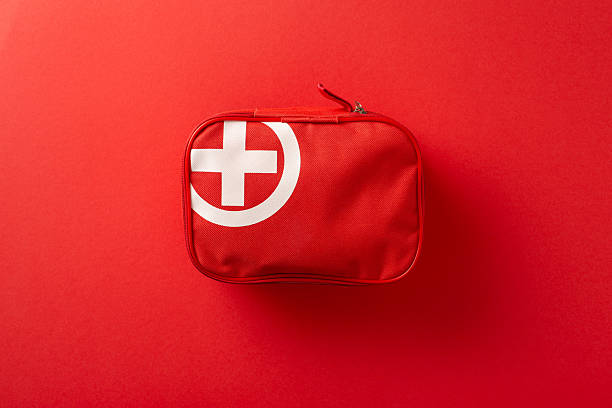 istock Vivid image of a red first aid kit featuring a white cross, symbolizing emergency preparedness and healthcare essentials, set against a red background, conveying safety, readiness, and health 2210278813