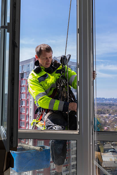 istock Worker Adjusting Window in High-Rise Building: Safety and Precision in Action while Cleaning Windows on a Bright Sunny Day 2210285342