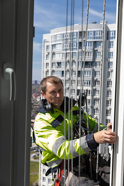 istock A Professional Window Cleaner Suspended at Height, Focused on His Task While Working on a Modern High-Rise Building in Bright Sunlight, Showcasing Urban Life and Safety 2210285729
