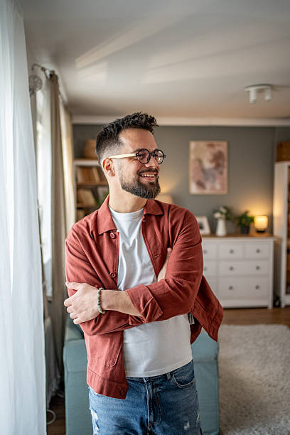 istock Smiling young man relaxing at home with arms crossed 2210289848