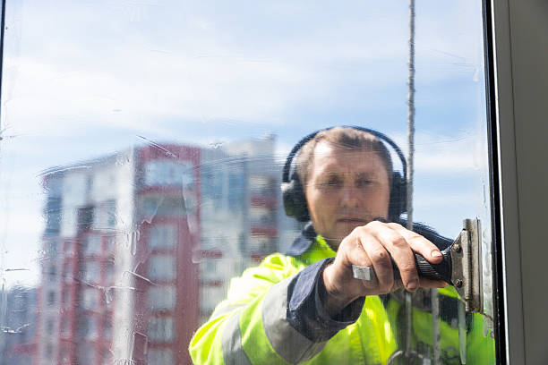 istock A Hardworking Window Cleaner Engaged in the Task of Cleaning Glass Surfaces While Sporting Headphones, Displaying Composure and Focus on the Job at Hand 2210289861