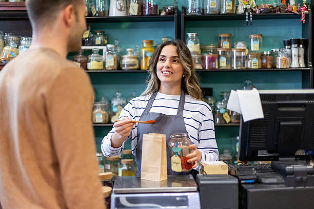 istock Shop assistant serving spice to customer in zero waste store 2210290557