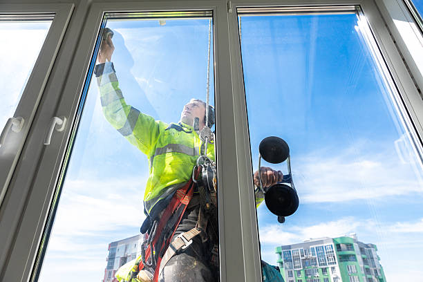 istock Professional Window Cleaner Performing High-Rise Cleaning on a Bright Sunny Day with a Clear Sky and Modern Building in the Background 2210290683