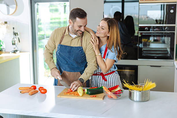 istock Loving couple preparing a meal together in their brightly lit modern kitchen 2210294096
