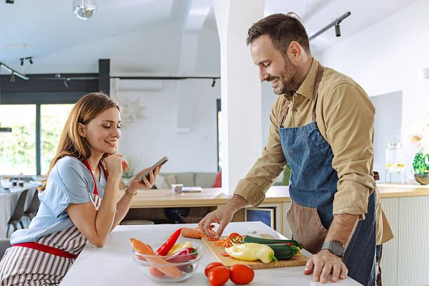 istock Couple enjoying quality time cooking fresh vegetables together in modern kitchen 2210294126