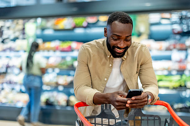 istock Man Shopping in a Grocery Store While Checking His Smartphone 2210300123