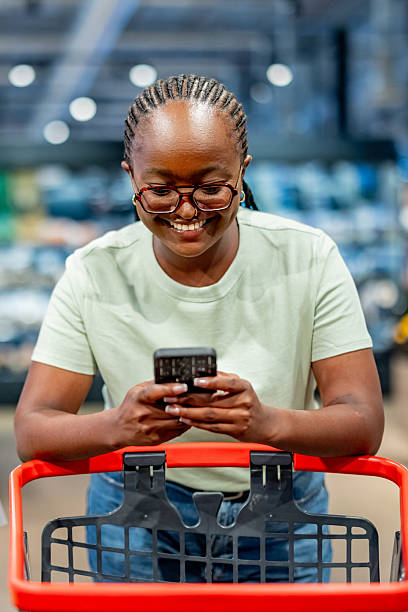 istock Young Woman Shopping While Using a Smartphone in a Modern Store Setting 2210300129
