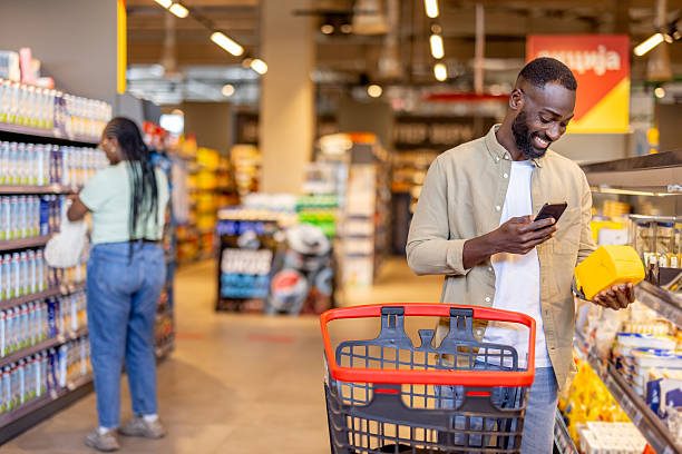 istock Man Shopping for Groceries While Using Smartphone in a Modern Store 2210300229