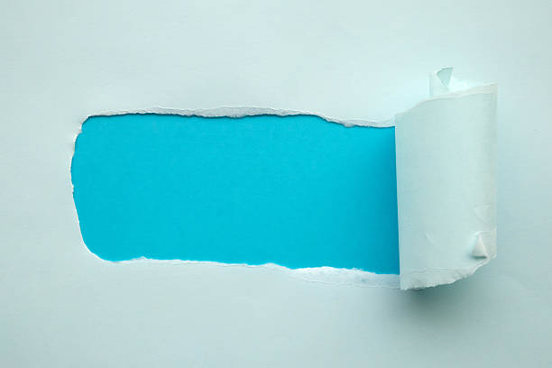 istock Blue torn paper rolled edge with space on blue background 2210300923