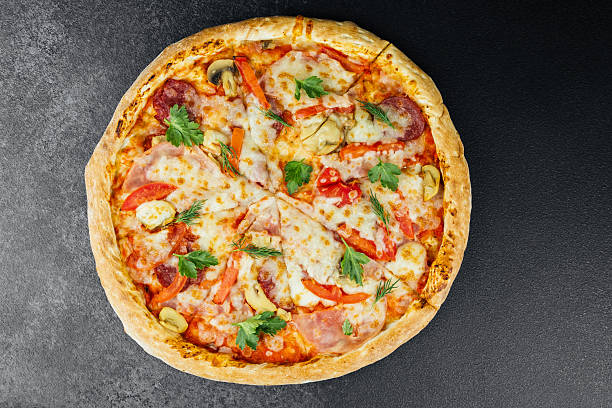 istock Tasty pizza with fresh toppings and melted cheese on dark backdrop 2210301949