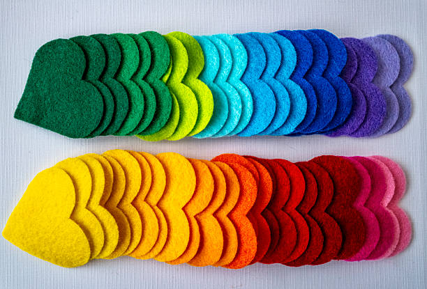 large collection of coloured felt hearts on a grey background
