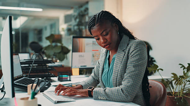 istock Black woman, documents and typing by computer in office for project, admin and review for proposal. Person, paperwork and notes for research, planning or feedback for perspective at creative agency 2210314458