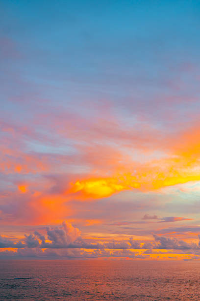 istock Serene sunset seascape with rich orange clouds and fading twilight light. 2210322041