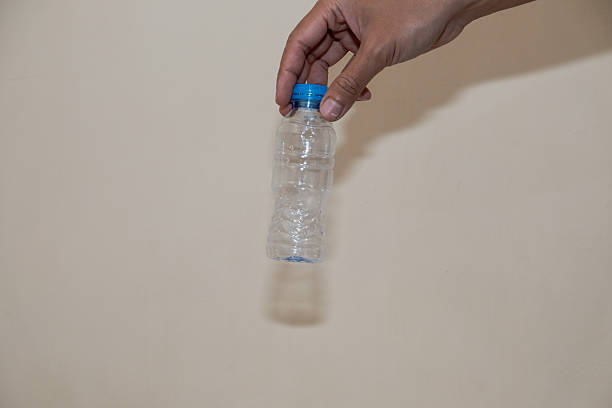 istock Close up of a man hand holding empty plastic water bottle on white background 2210323254