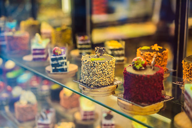 Different types of cakes in pastry shop glass display.