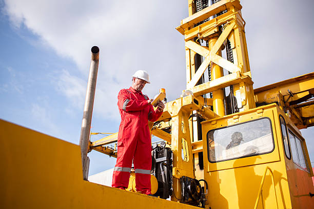 istock Engineer or worker team are standing forklift or truck vehicle are working appear discussing or reviewing document, likely related inspect container factory and industry transportation import export. 2210326043