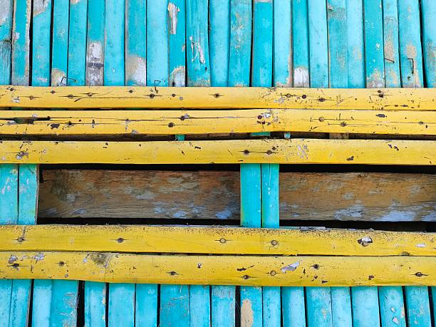Colorful bamboo wall painted in vibrant blue and yellow. Perfect for backgrounds, creative designs, tropical themes, or rustic textures
