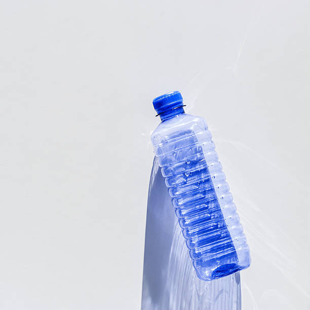 istock Blue plastic bottles at sunlight shadow on blue white background, top view empty plastic bottle for water half litre, minimal design. Pollution, plastic garbage, environmental protection concept 2210328460