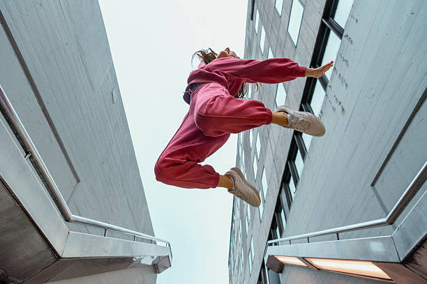 istock Woman dancer jumping at subway station, low angle view 2210329403