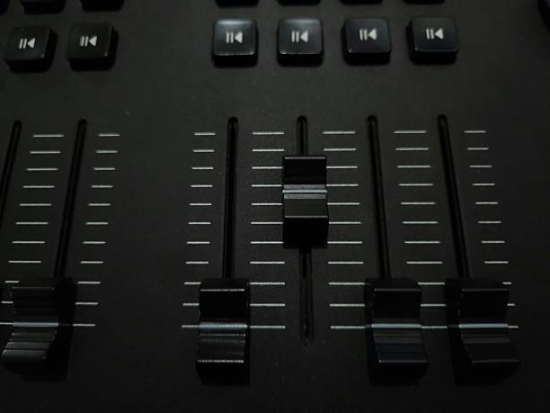 Close-up view of a lighting or audio control panel with sliders and buttons.