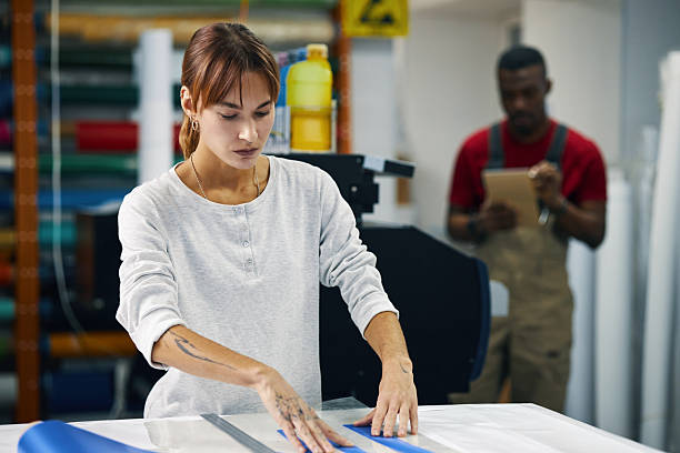 istock Woman Cutting Paper Stripes At Her Workplace In Workshop 2210331516