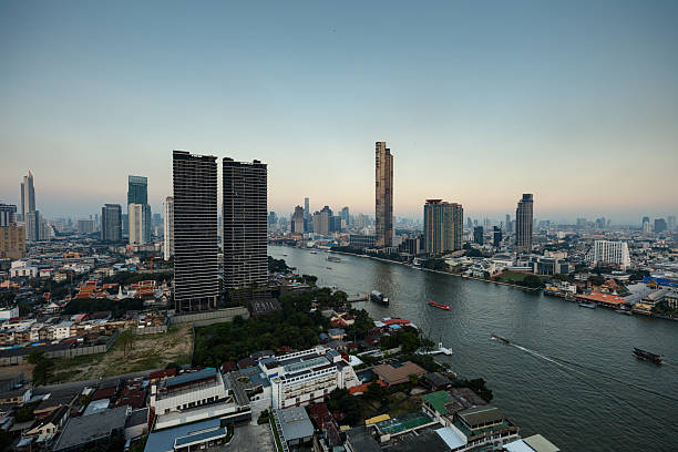 Wide shot of Khlong San and Sathon in Bangkok, Thailand, looking east across the Chao Phraya River from a high window in Thon Buri. Shot during the day. This file is part of a series of shots taken at different times from the same location, matching shots are available.