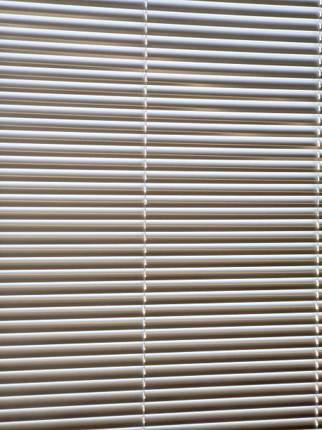 istock A row of white blinds with a light shining through them 2210335348