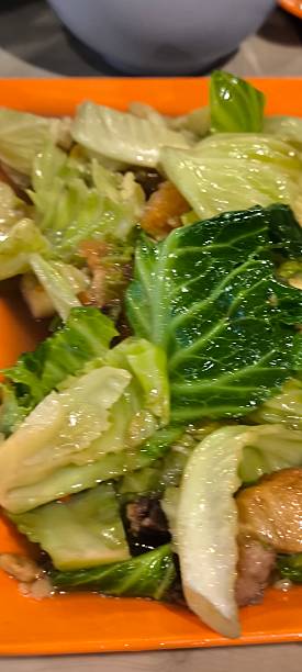 istock Stir-fried morning glory and crispy pork on an orange plate 2210335589