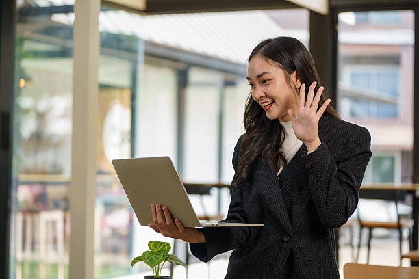 istock A young Asian businesswoman is standing at her desk using a laptop while working on a marketing strategy and business development plan in a modern office. 2210337762