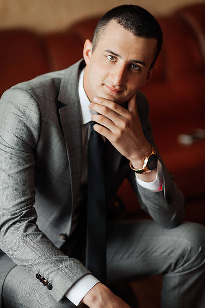 istock A man in a suit and tie is sitting on a couch 2210338793
