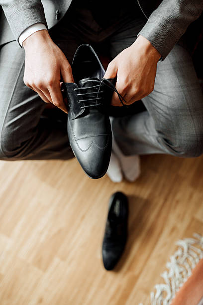 istock A man is putting on a black shoe 2210338795