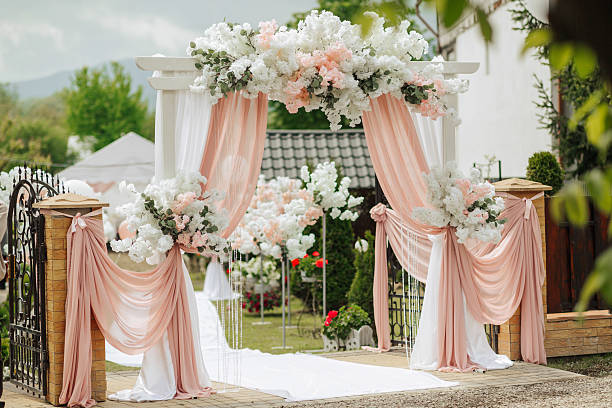 istock A wedding ceremony is taking place in a garden with a white archway 2210338830