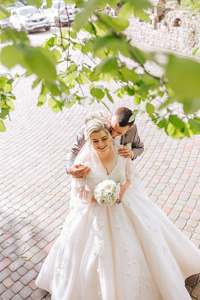 istock A bride and groom are kissing under a tree 2210338862