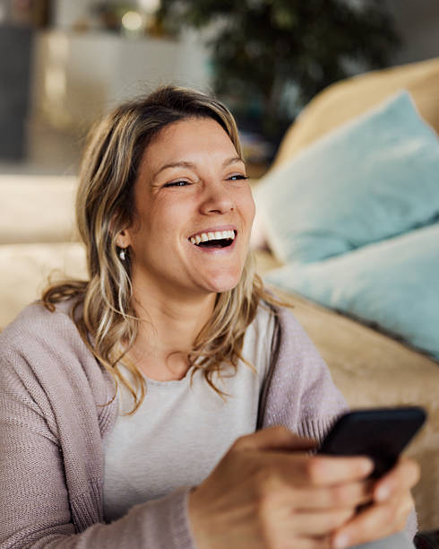 istock Cheerful woman using cell phone at home. 2210339810