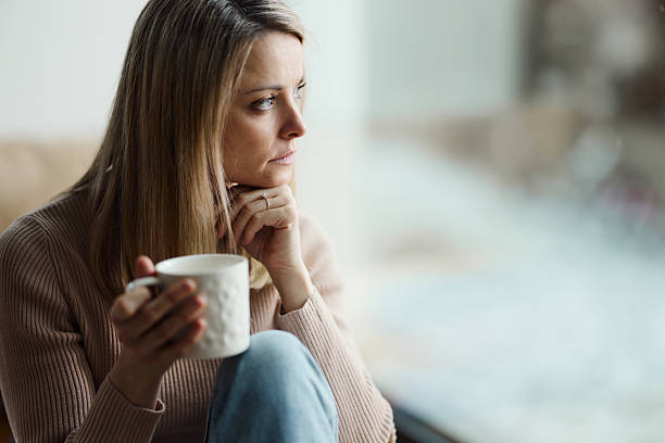 istock Thoughtful woman during coffee time by the window. 2210339999