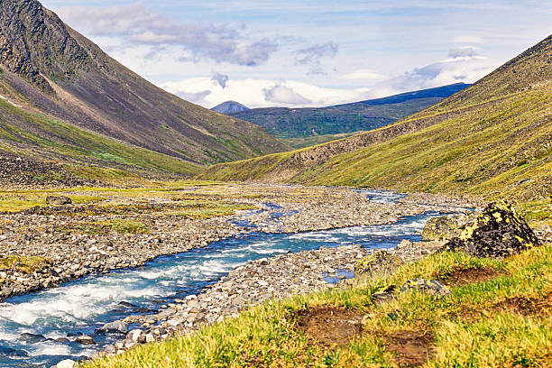 istock River with running water in a mountain valley 2210340325