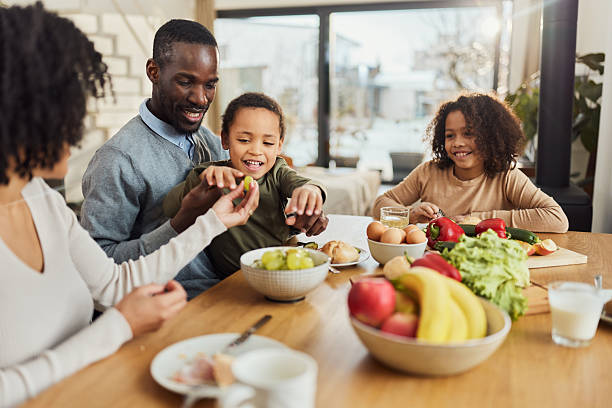 istock Happy black family enjoying in a meal at dining table. 2210340948