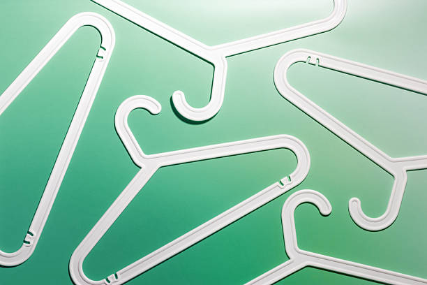istock Top view minimal style pattern of white plastic hangers with hooks on white green background. Flat lay with Clothes rack for hanging garments. Minimal trend photo, lifestyle or interior design concept 2210341304