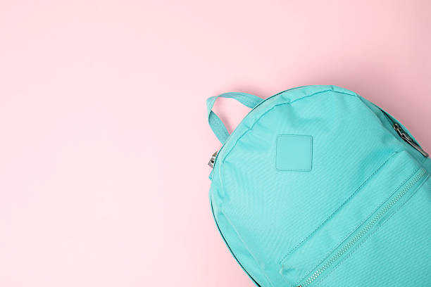 istock One turquoise backpack on pink background, top view. Space for text 2210342850