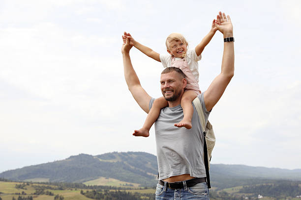 istock Happy tourist with his daughter and backpack travelling in mountains. Space for text 2210343496