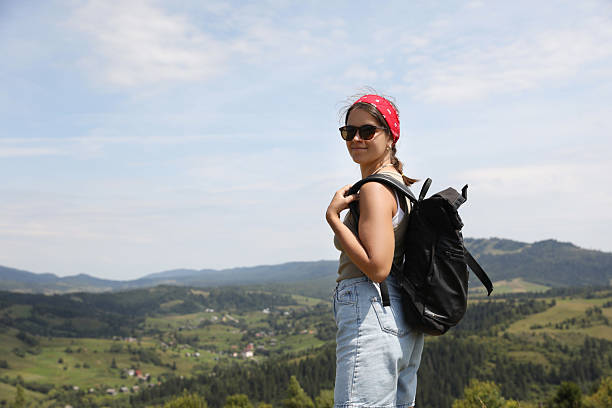 Smiling tourist with backpack in mountains. Space for text